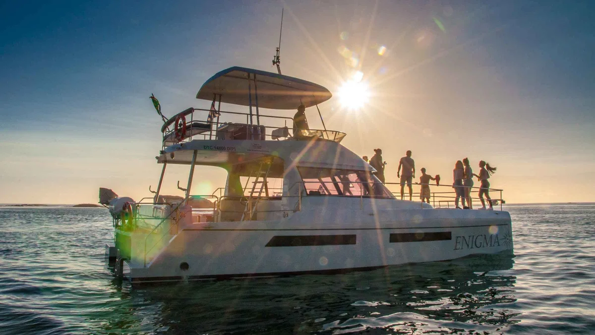 Guests on the deck of a luxury catamaran at sunset on a Prosecco cruise from the V&A Waterfront, Cape Town
