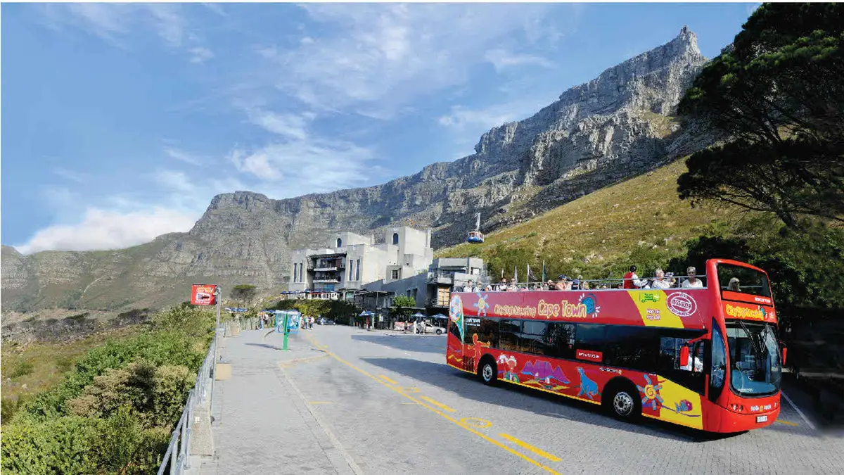 Open-top City Sightseeing bus rounding the Sea Point coast on a hop-on hop-off pass, Cape Town